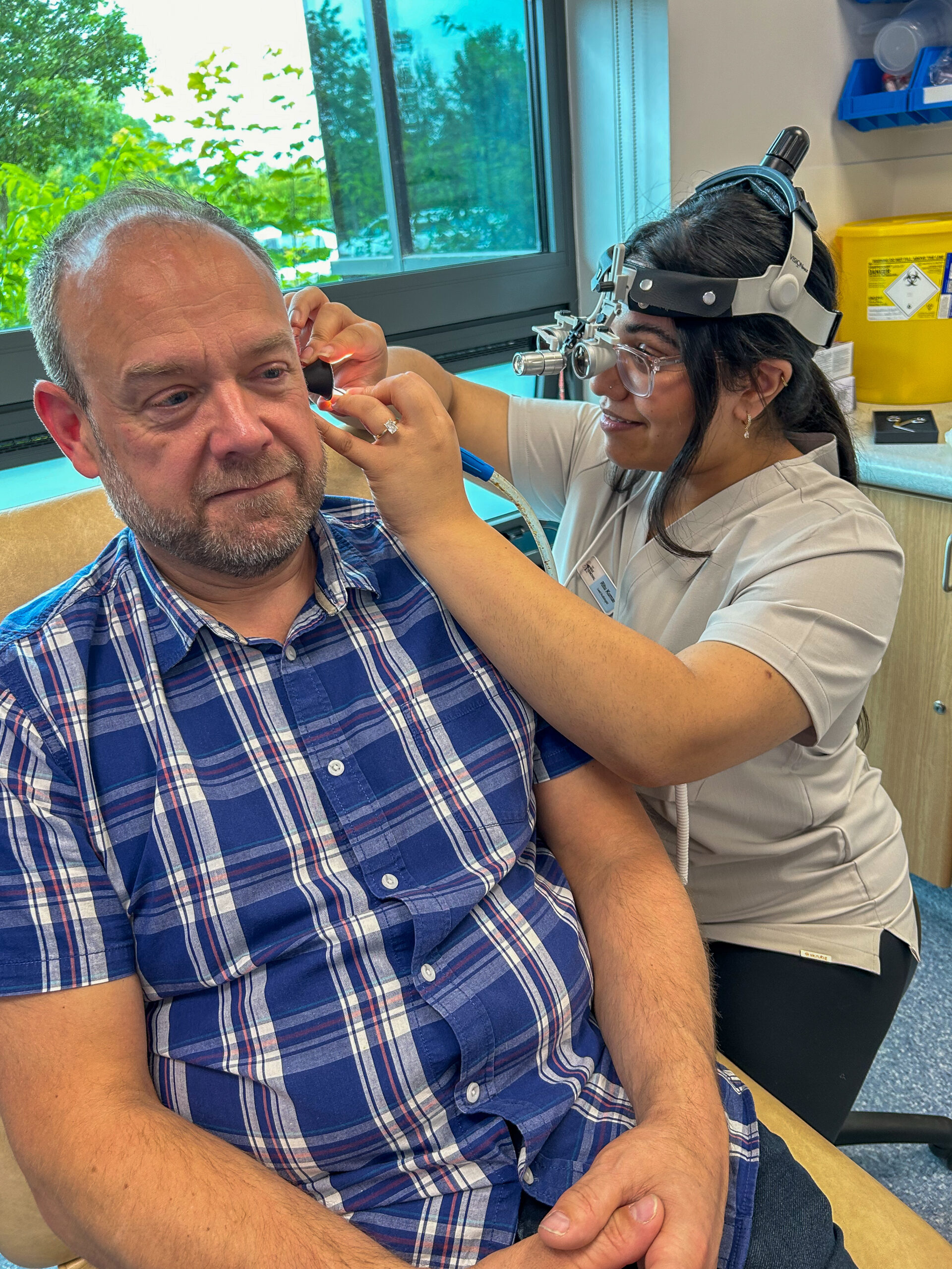 Senior audiologist examining a client ear